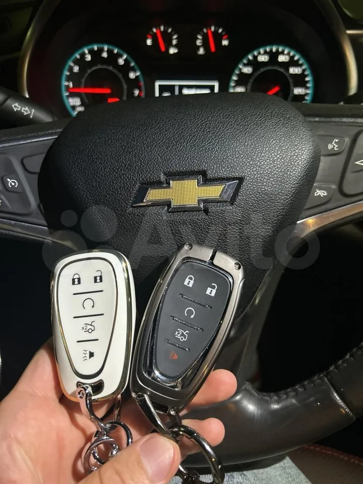 Автоключи Chevrolet на фоне руля автомобиля